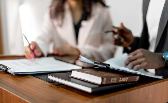 A lawyer and a client reviewing documents at a desk with 